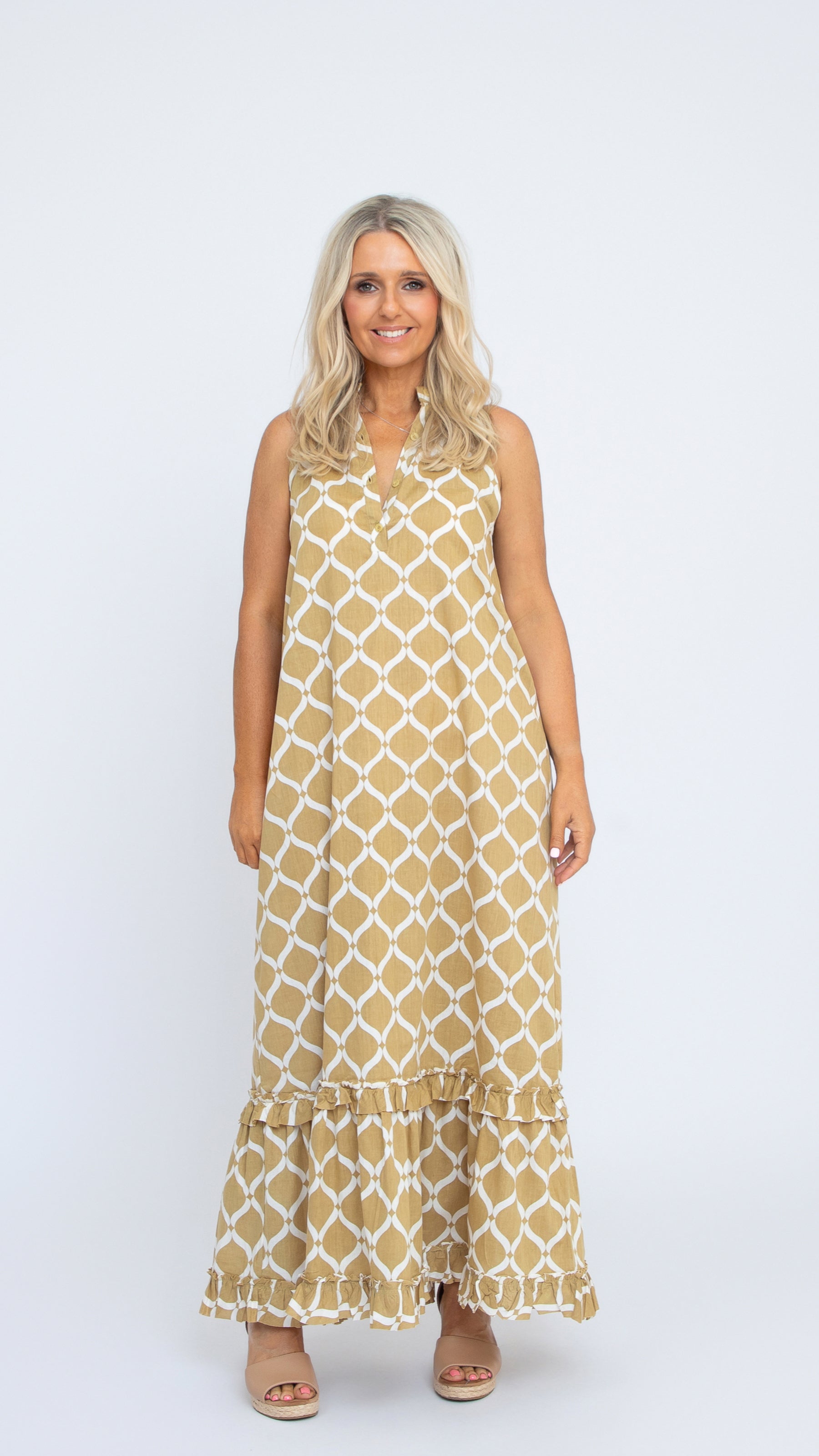 Donna Dress by Nancy The Label. Geometric Gold Trellis Print in Cotton. Maxi dress with V-neck and tiered skirt. Comes with matching belt.