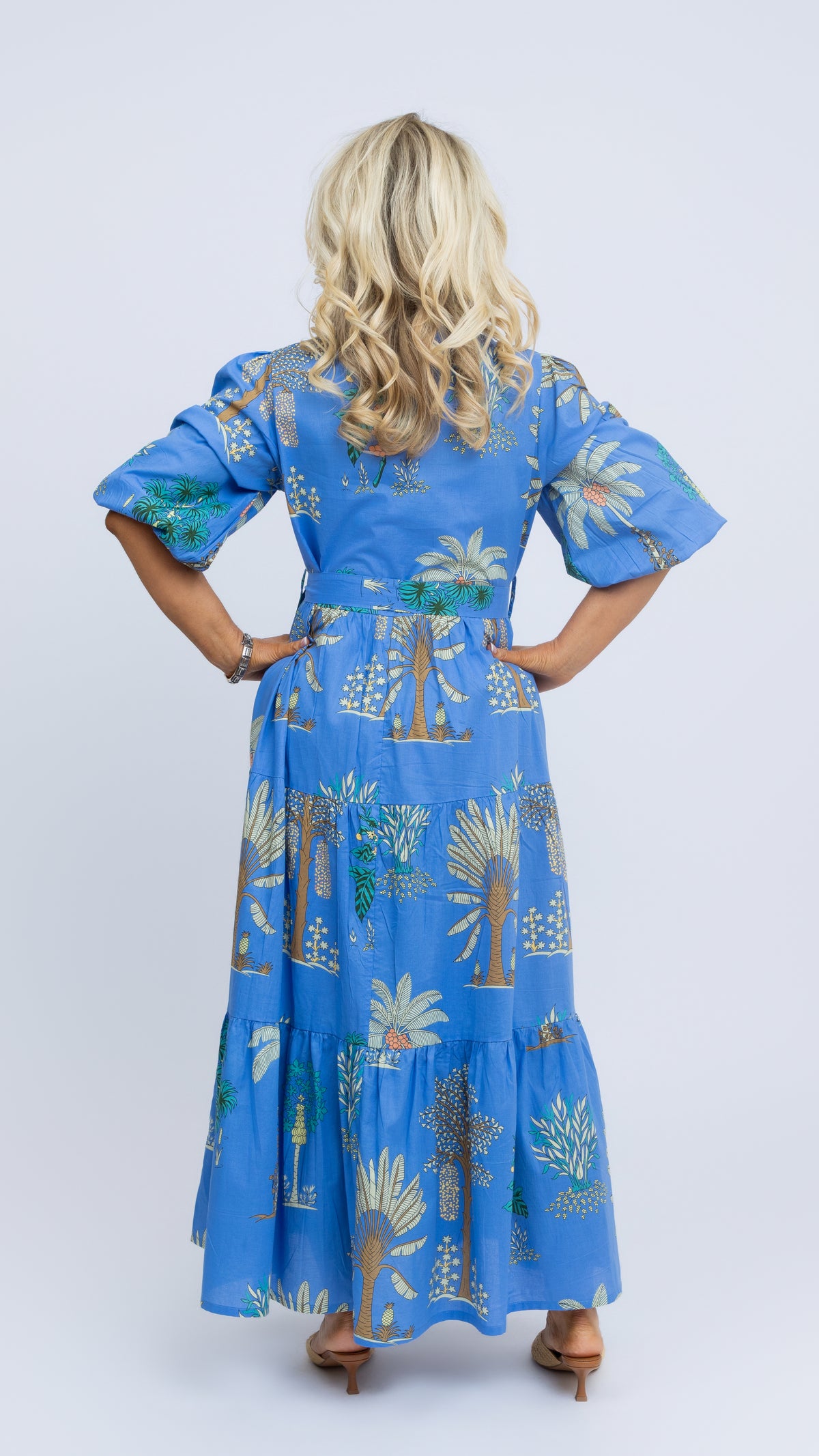Model wearing the Mandy maxi dress by Nancy The Label in blue Arboretum print, made from 100% cotton, rear view.