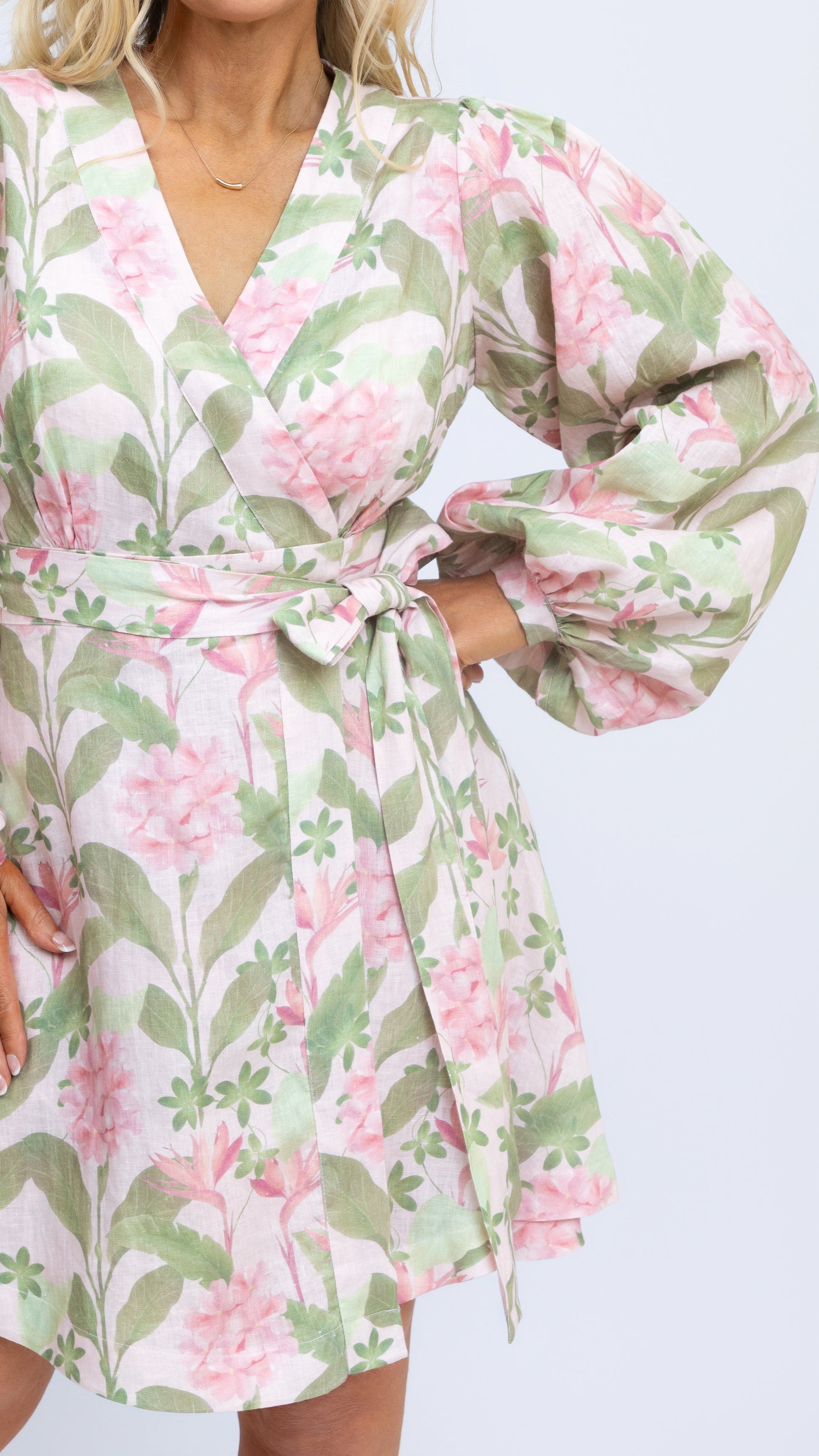 A close up view of Nancy The Label's Margot Linen Mini Wrap Dress in our bespoke Tropical Botanica print